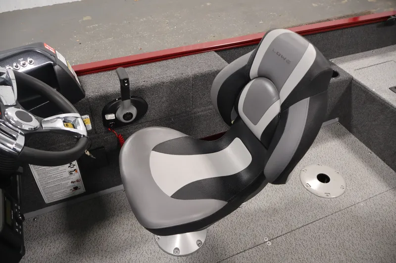 Slide: The Image of 2027 Lowe Fishing Machine 1775SC boat interior with steering wheel and cushioned seat. - 29