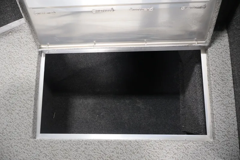 Slide: The Image of Storage compartment in 2027 Lowe Fishing Machine 1775SC boat, featuring carpeted interior. - 16