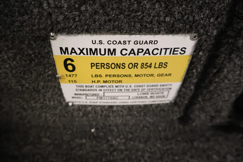 Slide: The Image of U.S. Coast Guard capacity label on 2027 Lowe Fishing Machine 1775SC boat. - 28