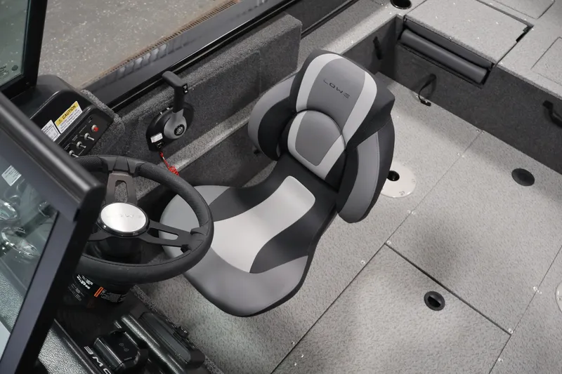 Slide: The Image of 2027 Lowe Fishing Machine 1875 interior with steering wheel and cushioned seat. - 26