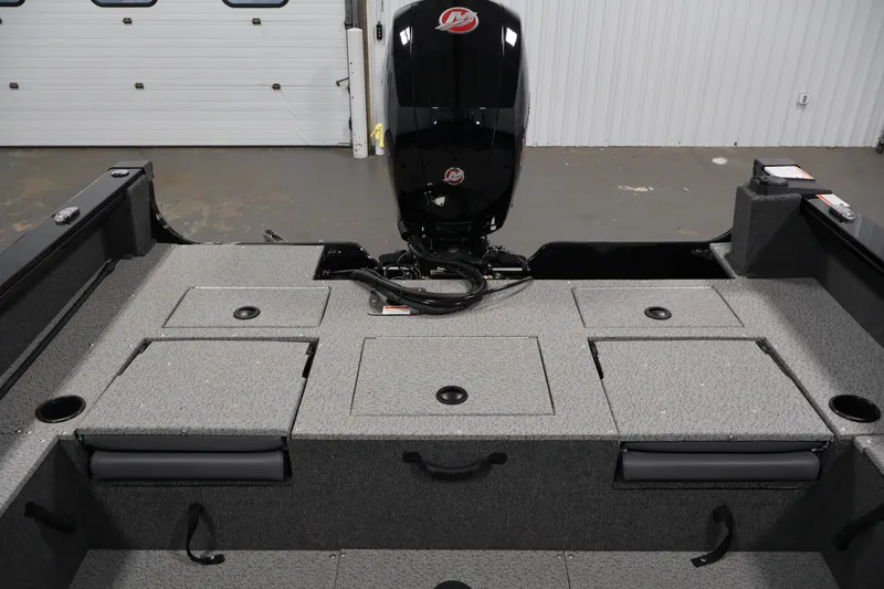 Slide: The Image of 2027 Lowe Fishing Machine 1875 boat interior with storage compartments and motor. - 29