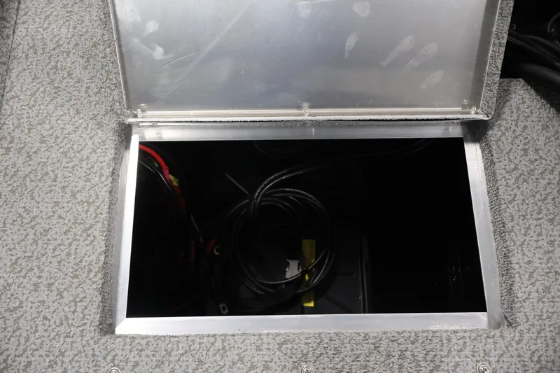 Slide: The Image of Open storage compartment in 2027 Lowe Fishing Machine 1875 boat, showing cables inside. - 34