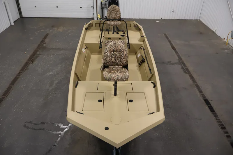 Slide: The Image of 2027 Lowe Roughneck RX1860 Tunnel Jet boat with camo seats in a garage setting. - 8