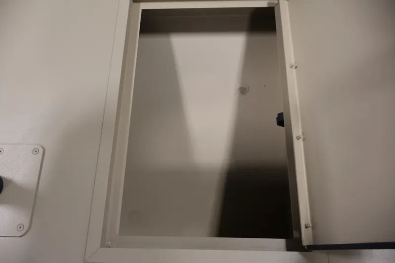 Slide: The Image of Open storage compartment on a 2027 Lowe Roughneck RX1860 Tunnel Jet boat. - 12