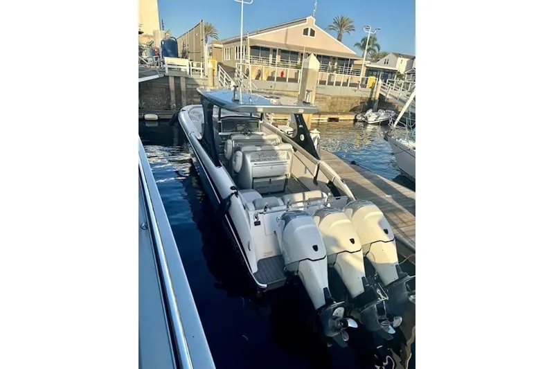 Slide: The Image of 2016 Mystic M4200 boat docked with triple outboard engines. - 3