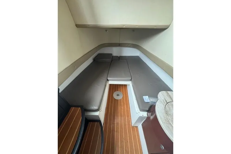 Slide: The Image of Interior cabin of 2016 Mystic M4200 boat with cushioned seating and wooden flooring. - 6