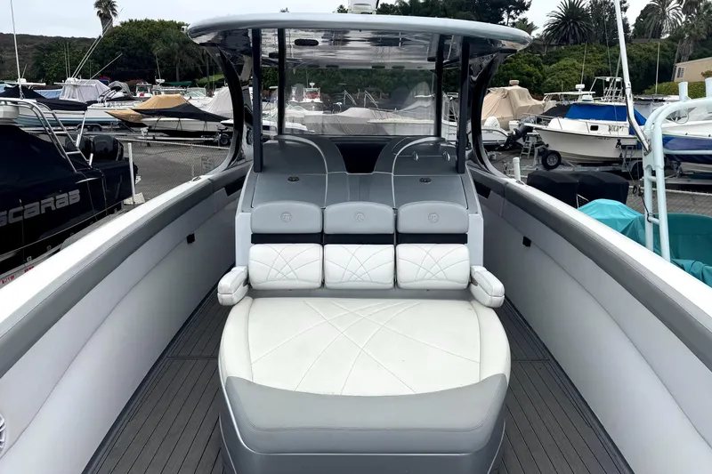Slide: The Image of 2016 Mystic M4200 boat with sleek seating, docked among other vessels. - 9