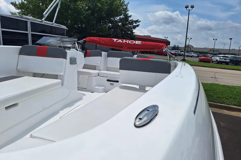 Slide: The Image of 2026 Tahoe T18 boat with sleek white interior and red accents, parked outdoors. - 2