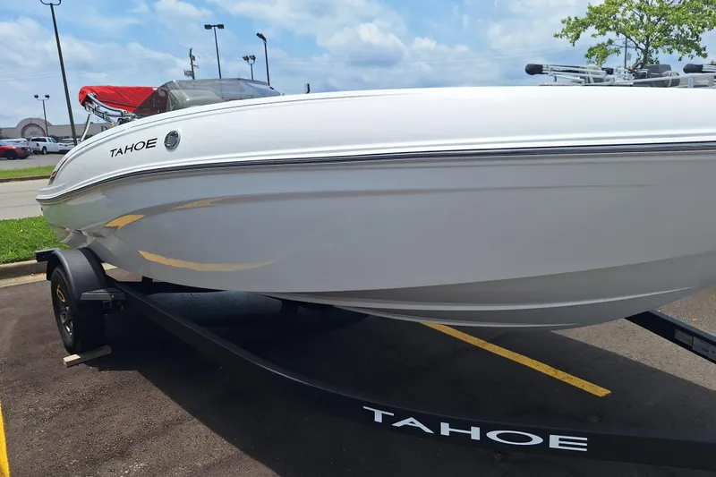 Slide: The Image of 2026 Tahoe T18 boat on trailer in parking lot, under a partly cloudy sky. - 1