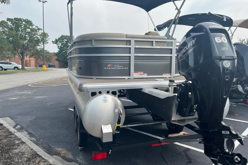 Slide: The Image of 2025 Sun Tracker Party Barge 20 DLX pontoon boat with Mercury 60 HP engine in parking lot. - 4