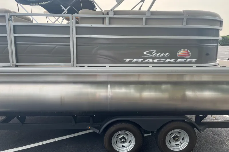 Slide: The Image of 2025 Sun Tracker Party Barge 20 DLX pontoon boat on trailer, side view. - 3