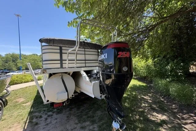 Slide: The Image of 2022 Lexington 623 boat with Suzuki 250 outboard motor, parked outdoors under trees. - 4