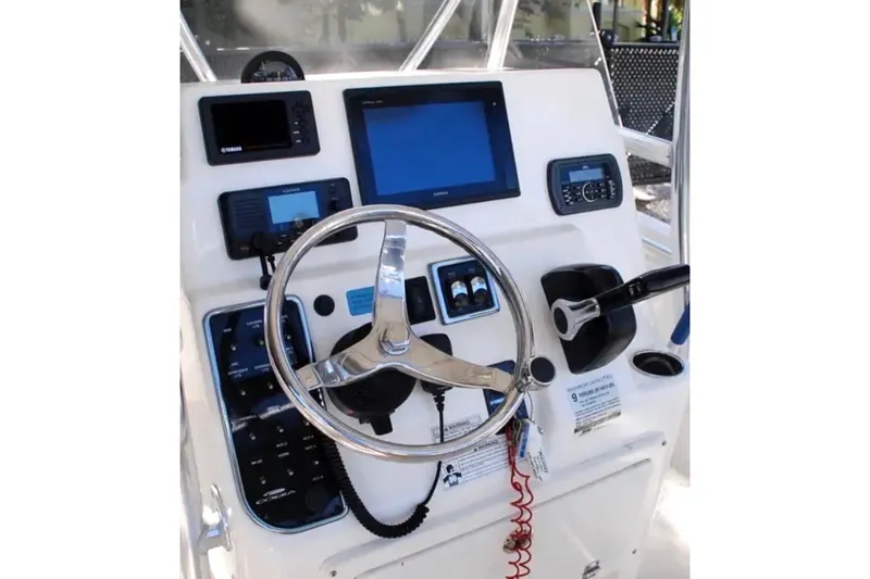 Slide: The Image of 2019 Cobia 220 Center Console boat dashboard with steering wheel and electronic controls. - 15