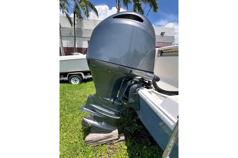 Slide: The Image of 2019 Cobia 220 Center Console boat with outboard motor on grass. - 19