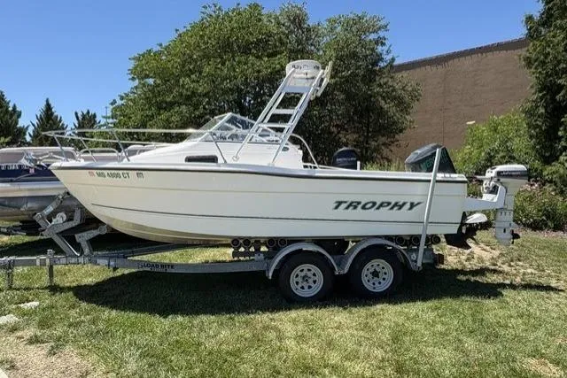 The Image of 2006 Trophy 1802 Walkaround boat on trailer, parked on grass, side view. - 1