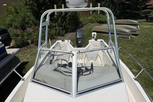 Slide: The Image of 2006 Trophy 1802 Walkaround boat with windshield and radar, parked on grass. - 10