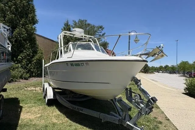 Slide: The Image of 2006 Trophy 1802 Walkaround boat on trailer, parked on grass under clear blue sky. - 2