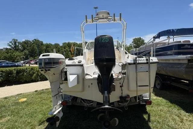 Slide: The Image of 2006 Trophy 1802 Walkaround boat with dual outboard motors, parked on grass. - 3