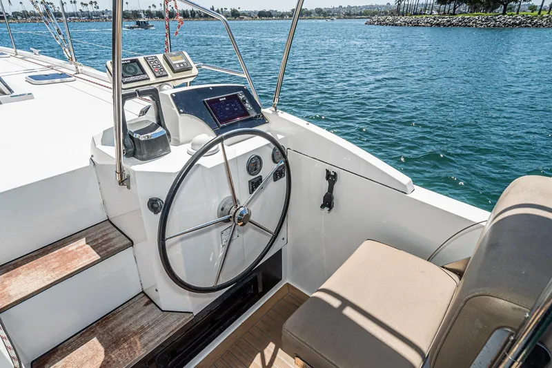 Slide: The Image of Helm of 2019 Nautitech 46 Open catamaran with navigation instruments, steering wheel, and ocean view. - 27