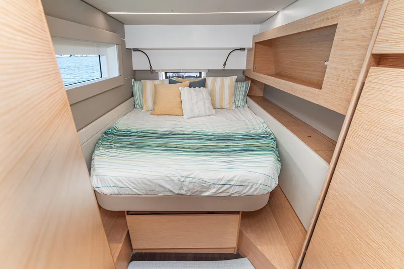 Slide: The Image of Cozy bedroom interior of 2019 Nautitech 46 Open catamaran with striped bedding and wooden accents. - 45