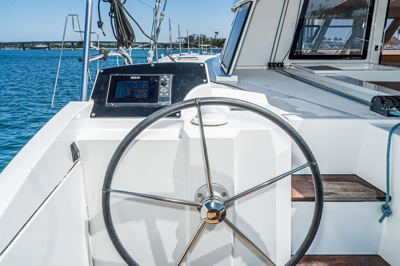 Slide: The Image of Steering wheel of 2019 Nautitech 46 Open catamaran with navigation display, docked on calm waters. - 25