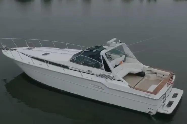 The Image of 1988 Sea Ray Sundancer 460 yacht on calm water, showcasing sleek design and spacious deck. - 1