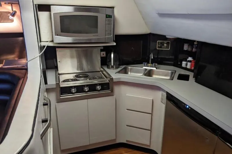 Slide: The Image of Compact kitchen in a 1988 Sea Ray Sundancer 460 yacht with stove, microwave, and sink. - 4