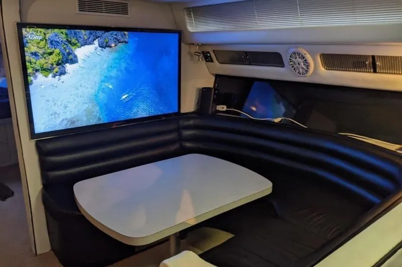 Slide: The Image of Interior of 1988 Sea Ray Sundancer 460 with a cozy dining area and large screen. - 5