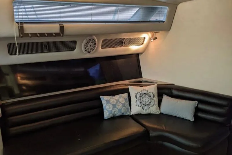 Slide: The Image of Interior of 1988 Sea Ray Sundancer 460 with black leather seating and decorative pillows. - 7