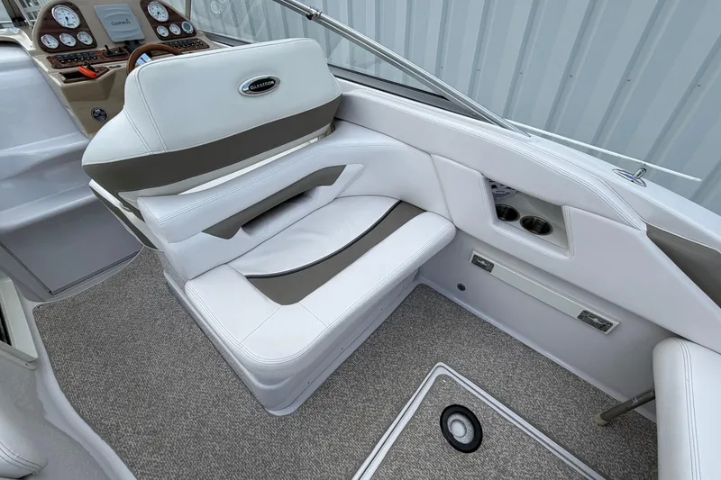 Slide: The Image of 2015 Glastron GS 289 boat interior with white seating and dashboard controls. - 11