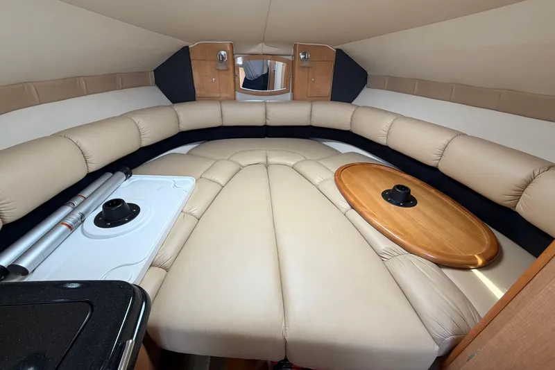 Slide: The Image of Interior of 2015 Glastron GS 289 boat with beige seating and wooden table. - 17