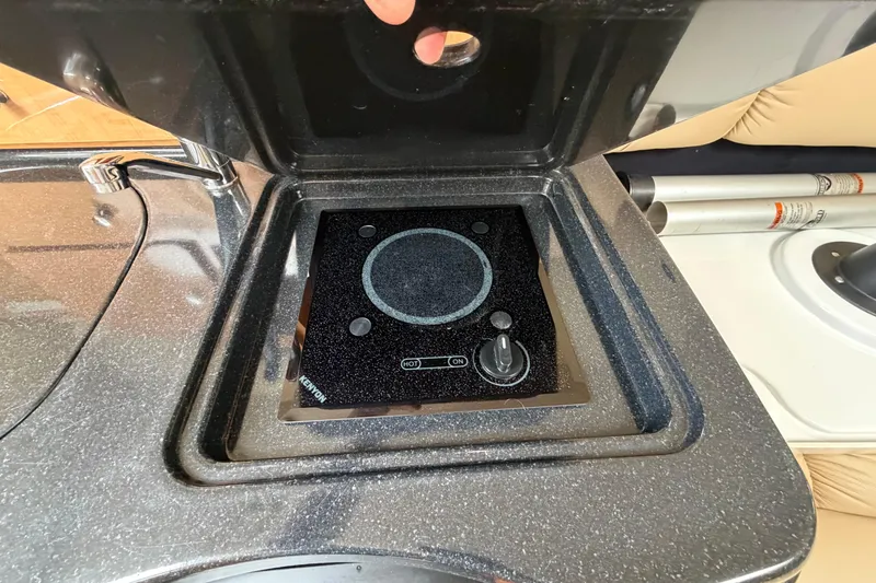 Slide: The Image of Built-in stove on 2015 Glastron GS 289 boat, featuring a sleek black design. - 20