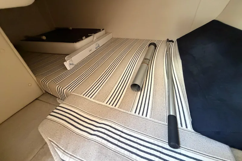 Slide: The Image of Interior of 2015 Glastron GS 289 boat with striped upholstery and metal poles. - 21
