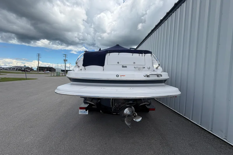 Slide: The Image of 2015 Glastron GS 289 boat parked near a metal building under cloudy skies. - 4