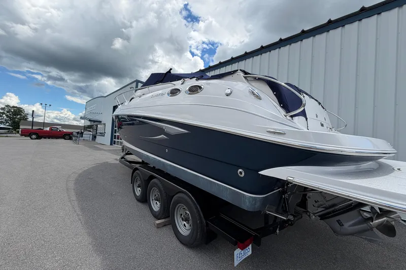 Slide: The Image of 2015 Glastron GS 289 boat on trailer, parked outside a building under cloudy sky. - 6