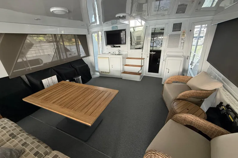 Slide: The Image of Interior of a 1998 Hatteras yacht featuring a cozy seating area and wooden table. - 15