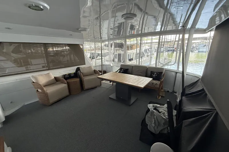 Slide: The Image of Spacious 1998 Hatteras yacht interior with comfortable seating and a wooden table. - 17