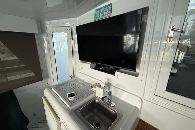 Slide: The Image of Interior of a 1998 Hatteras yacht featuring a sink and mounted TV. - 19