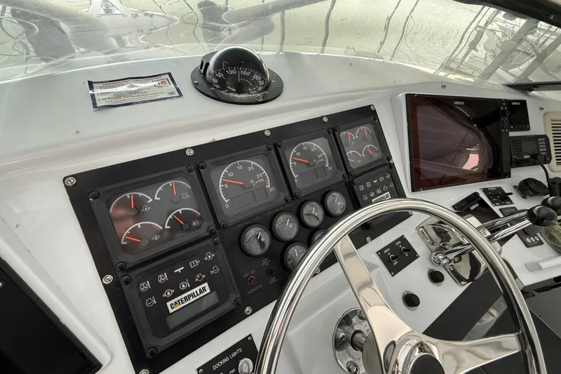 Slide: The Image of 1998 Hatteras yacht dashboard with gauges, steering wheel, and navigation equipment. - 24