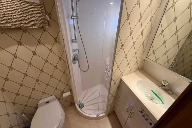 Slide: The Image of Compact bathroom in a 1998 Hatteras yacht with shower, sink, and toilet. - 33
