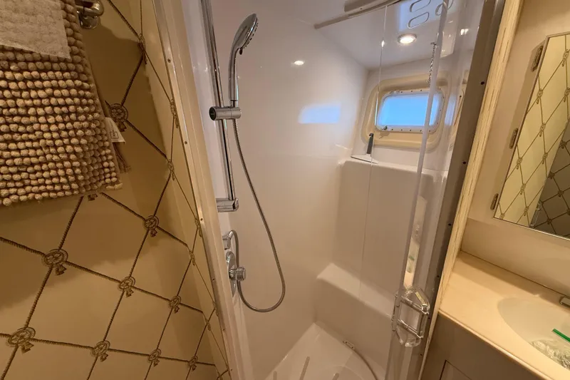Slide: The Image of Shower area in a 1998 Hatteras yacht with modern fixtures and nautical decor. - 34