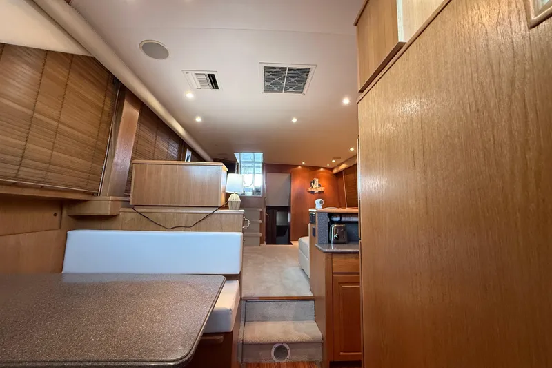 Slide: The Image of Interior of a 1998 Hatteras yacht featuring wood paneling and modern furnishings. - 36