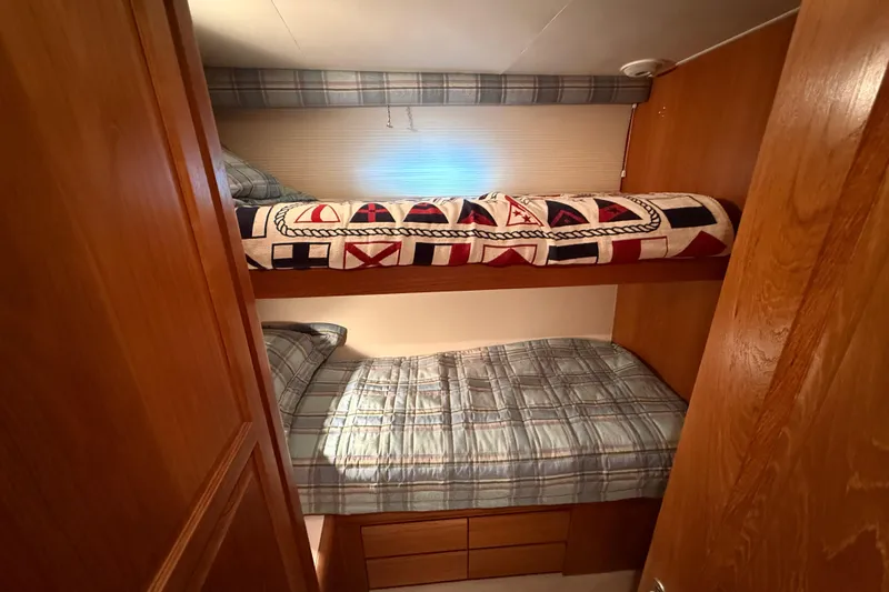 Slide: The Image of Cozy 1998 Hatteras yacht cabin with bunk beds and nautical-themed decor. - 39