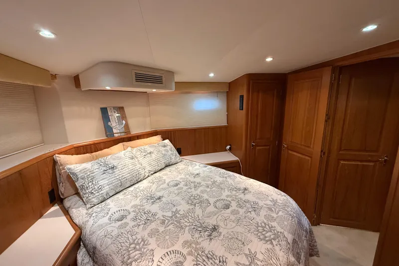 Slide: The Image of Luxurious 1998 Hatteras yacht bedroom with elegant wood paneling and cozy bedding. - 41