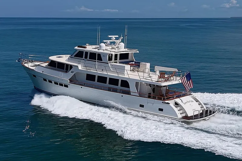 Slide: The Image of 2014 Marlow 80 Explorer yacht cruising on open sea with American flag. - 108