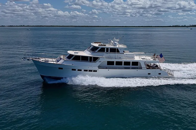 Slide: The Image of Luxury 2014 Marlow 80 Explorer yacht cruising on open water under a partly cloudy sky. - 111