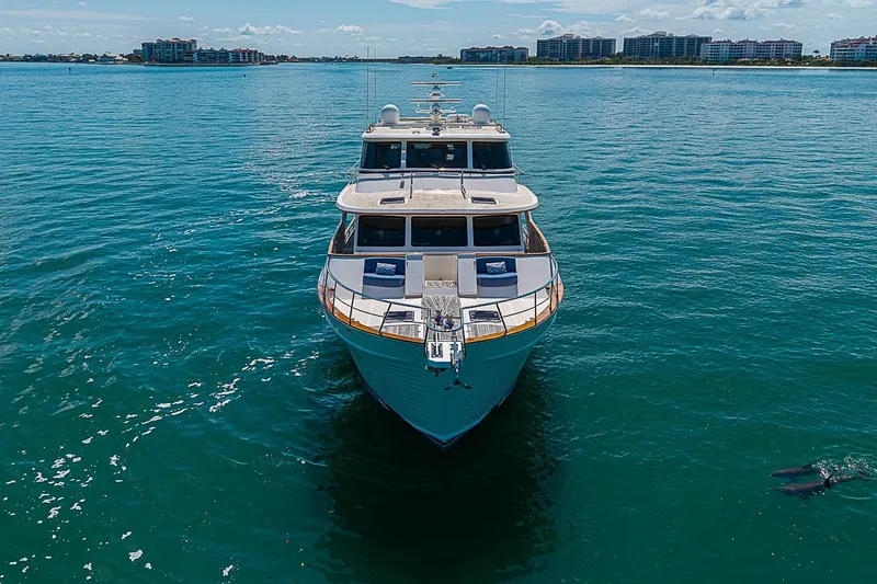 Slide: The Image of 2014 Marlow 80 Explorer yacht on calm blue waters, distant shoreline visible. - 2