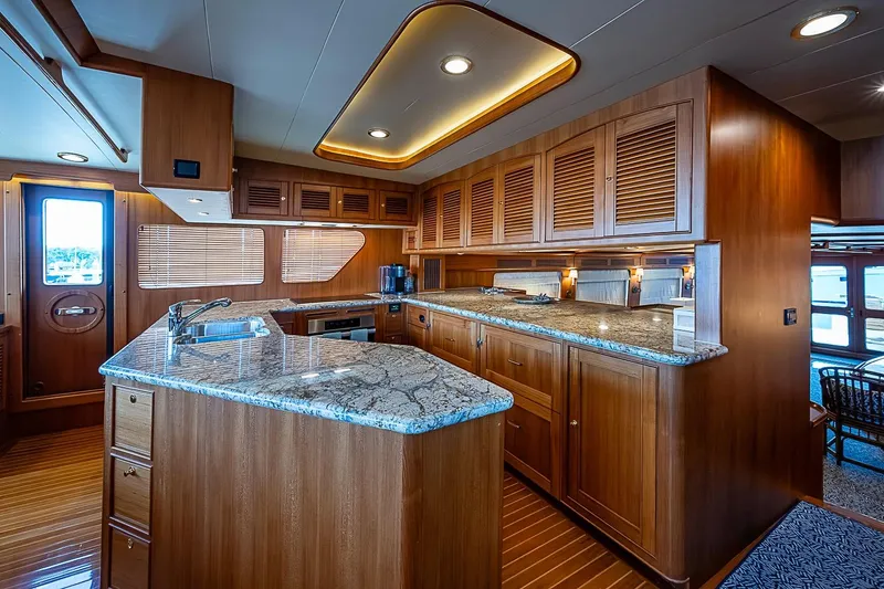 Slide: The Image of Luxurious kitchen interior of 2014 Marlow 80 Explorer yacht with wooden cabinetry and granite countertops. - 28