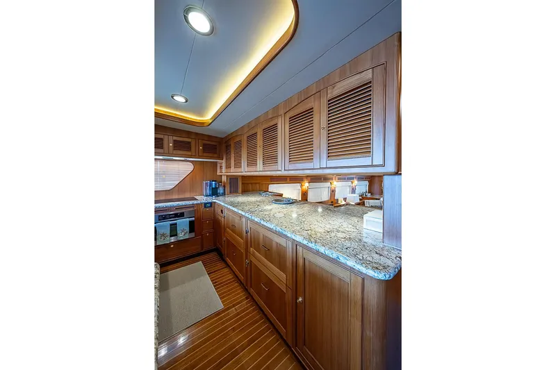 Slide: The Image of Luxurious kitchen interior of 2014 Marlow 80 Explorer yacht with wooden cabinetry and granite countertops. - 29