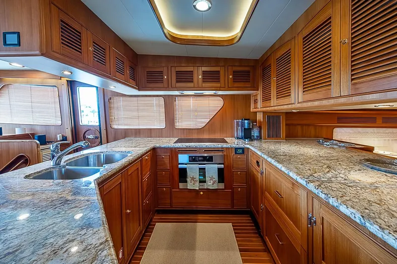 Slide: The Image of Luxurious kitchen interior of 2014 Marlow 80 Explorer yacht with wooden cabinetry and granite countertops. - 30